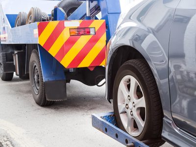 tow-truck-towing-a-broken-down-car-on-the-street-PE9HH3A.jpg